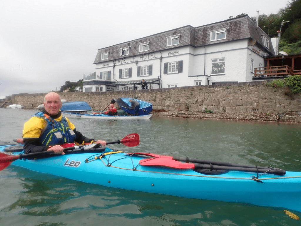A person in a kayak on the waterDescription automatically generated