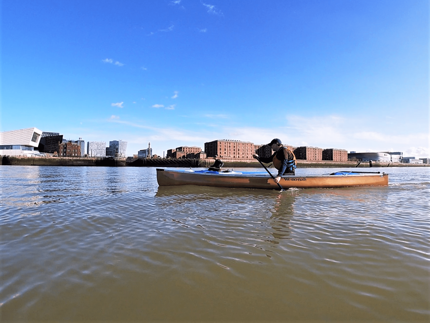 A person in a canoe on a riverDescription automatically generated