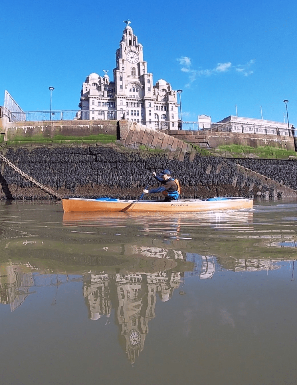 A person in a canoe on a riverDescription automatically generated