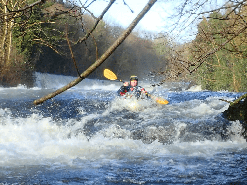 A person in a kayak in a river

Description automatically generated