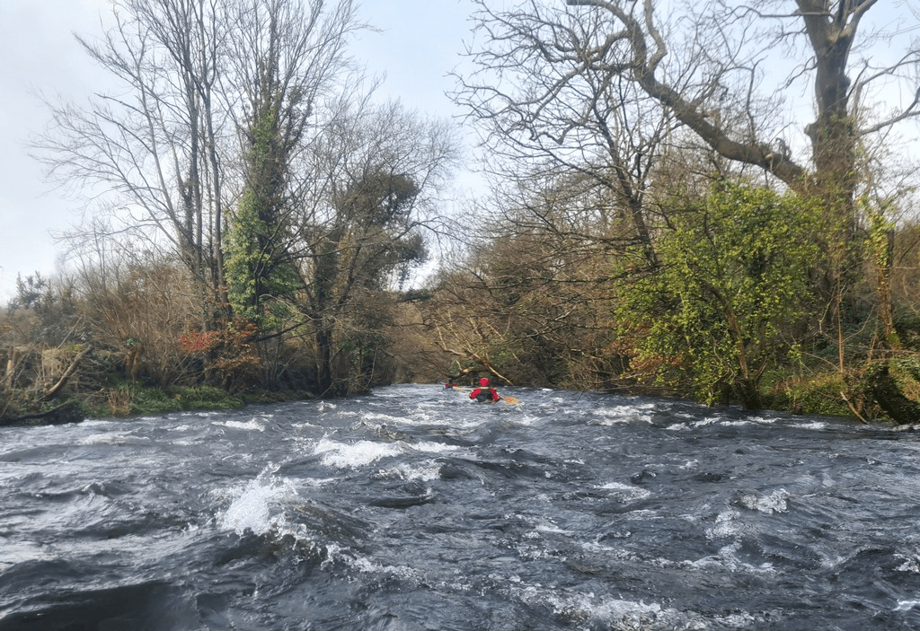 A river with a person in a kayakDescription automatically generated