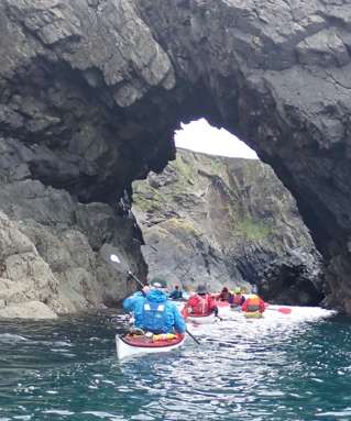 A group of people kayaking in a cave Description automatically generated