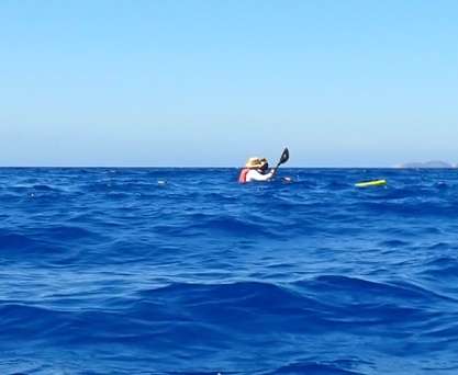A person in a kayak in the ocean
Description automatically generated