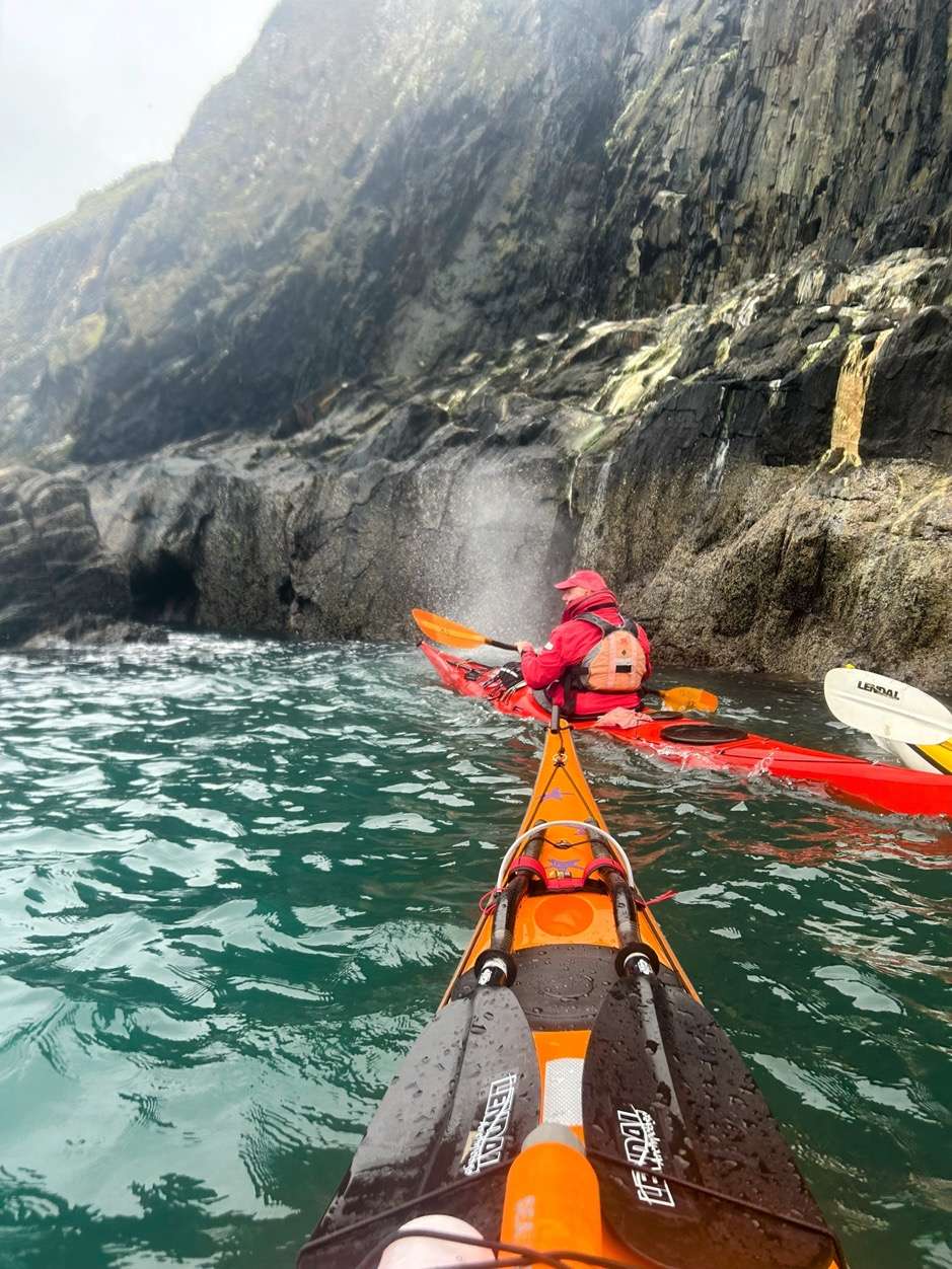 A person in a kayak on the waterDescription automatically generated