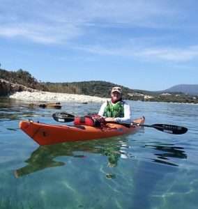 A person in a kayak on the water Description automatically generated