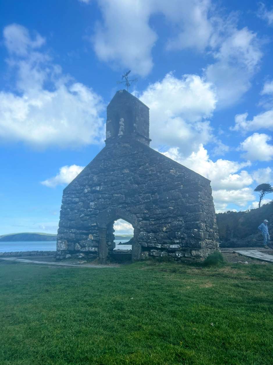 A stone building with a bell towerDescription automatically generated