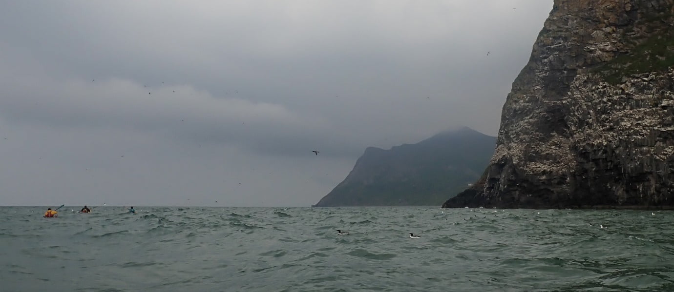 A body of water with a mountain in the background
Description automatically generated