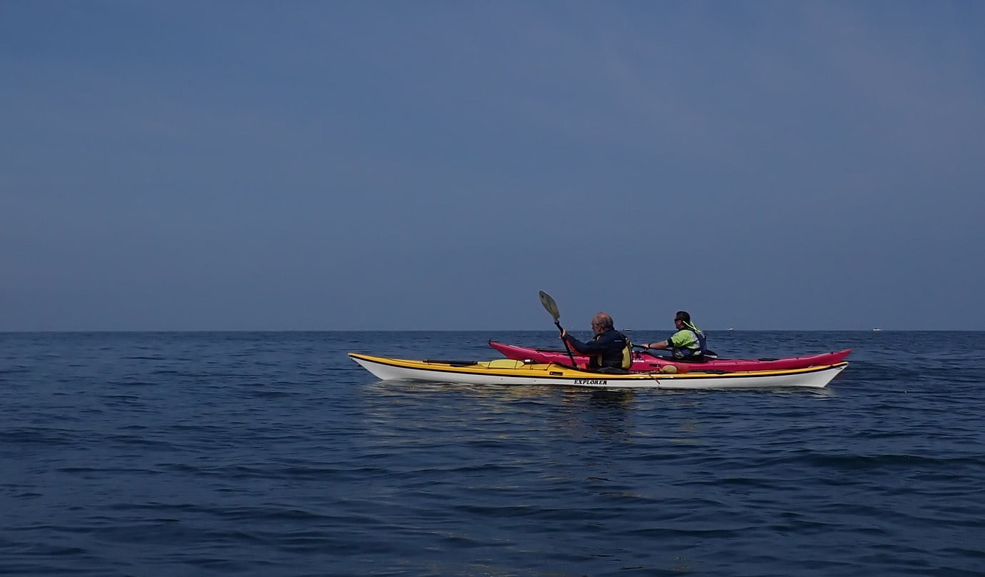 A couple of people in kayaks on the water
Description automatically generated