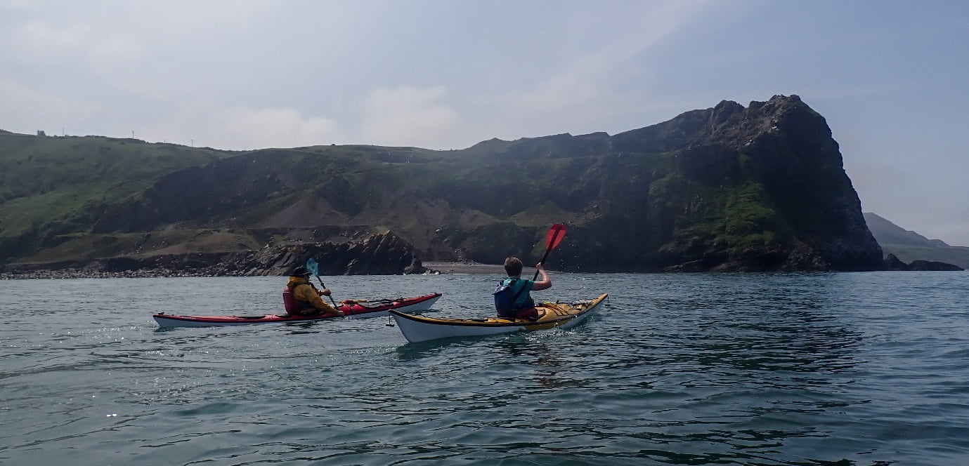 A couple of people kayaking on the water
Description automatically generated
