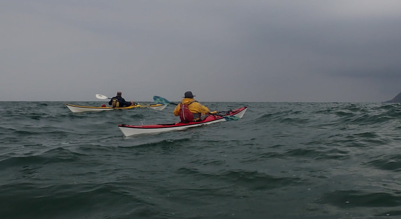 A group of people kayaking in the ocean
Description automatically generated
