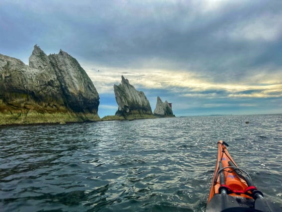 A person in a kayak on the waterDescription automatically generated