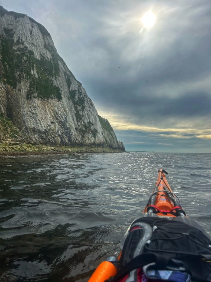 A person's leg on a kayak in the waterDescription automatically generated
