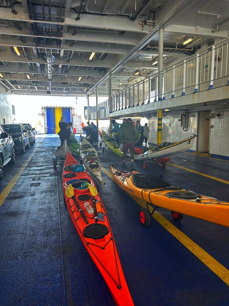 Several kayaks parked in a parking garageDescription automatically generated