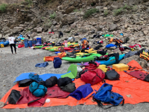 A group of kayaks on a rocky shore Description automatically generated