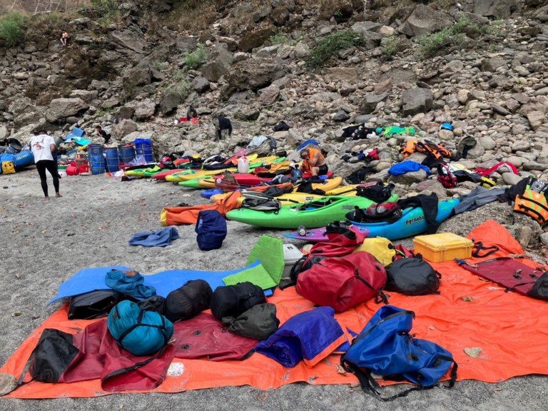 A group of kayaks on a rocky shore Description automatically generated