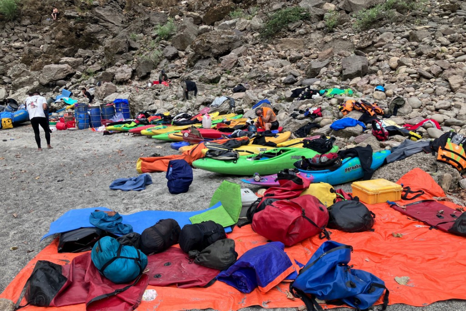 A group of kayaks on a rocky shore Description automatically generated