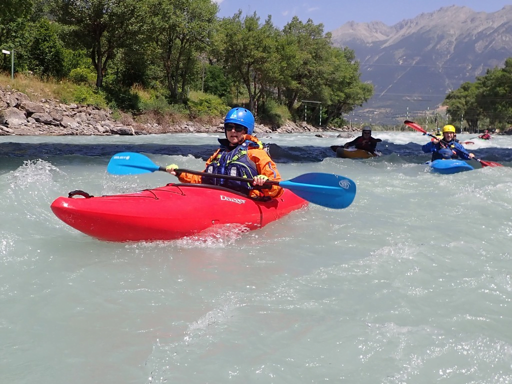A group of people in kayaks in a riverDescription automatically generated