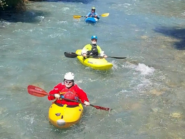 A group of people in kayaks in a river Description automatically generated