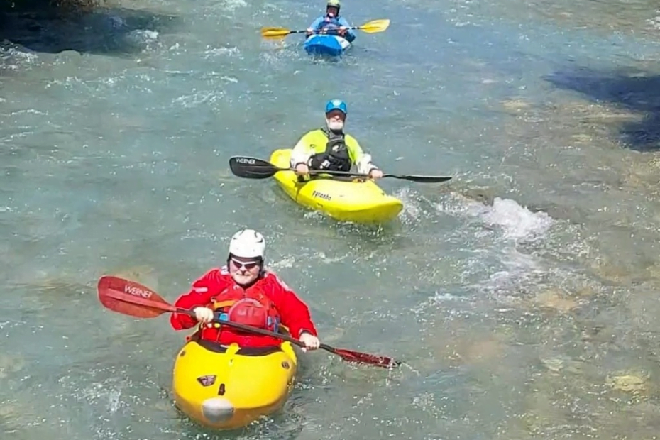 A group of people in kayaks in a river Description automatically generated