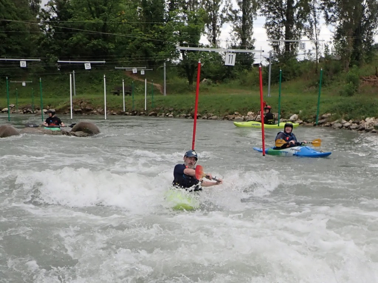 A group of people in kayaks in a river Description automatically generated