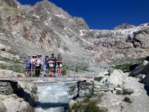 A group of people standing on a bridge over a river Description automatically generated