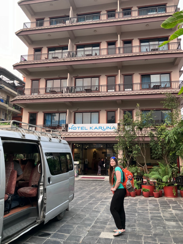 A person standing in front of a building Description automatically generated