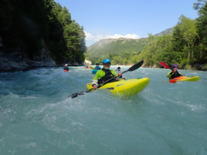 A group of people in kayaks in a river Description automatically generated