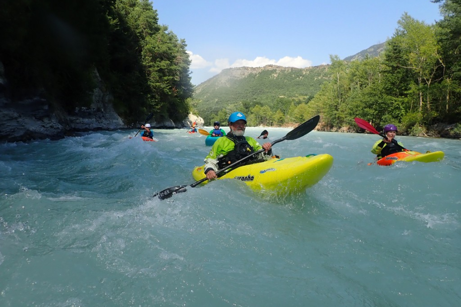 A group of people in kayaks in a river Description automatically generated