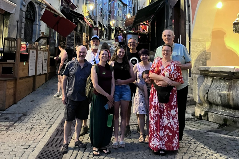 A group of people standing on a cobblestone street Description automatically generated