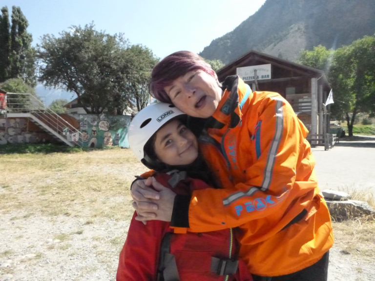 A person hugging a young child Description automatically generated