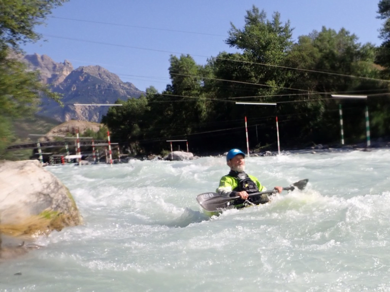 A person in a kayak in a river Description automatically generated
