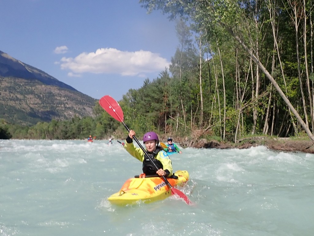 A person in a kayak on a riverDescription automatically generated
