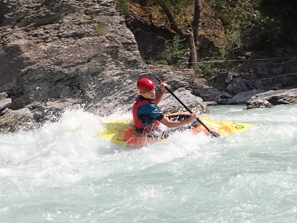 A person in a kayak on a riverDescription automatically generated