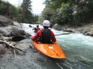 People kayaking in a river Description automatically generated