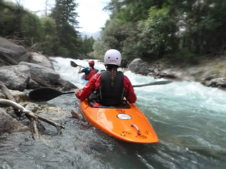 People kayaking in a river Description automatically generated