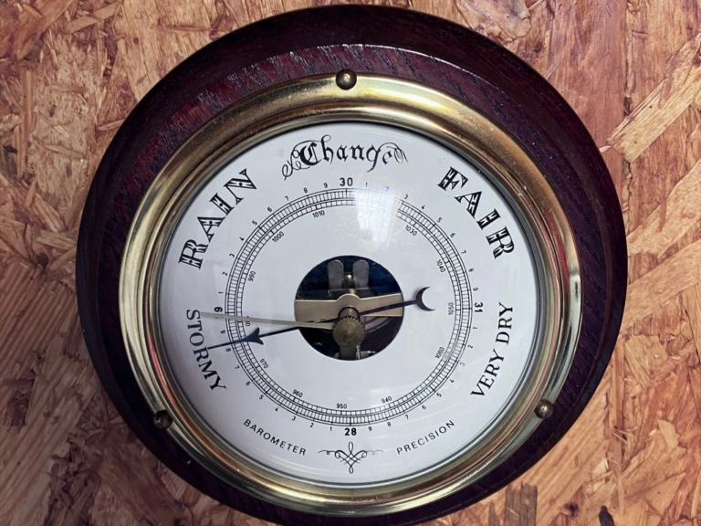 A circular clock with a white dial Description automatically generated