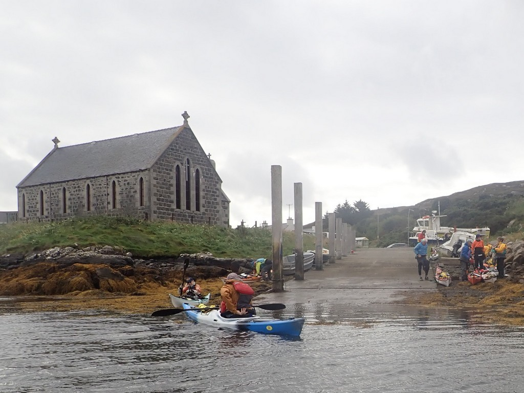 A group of people in kayaks on a body of waterDescription automatically generated