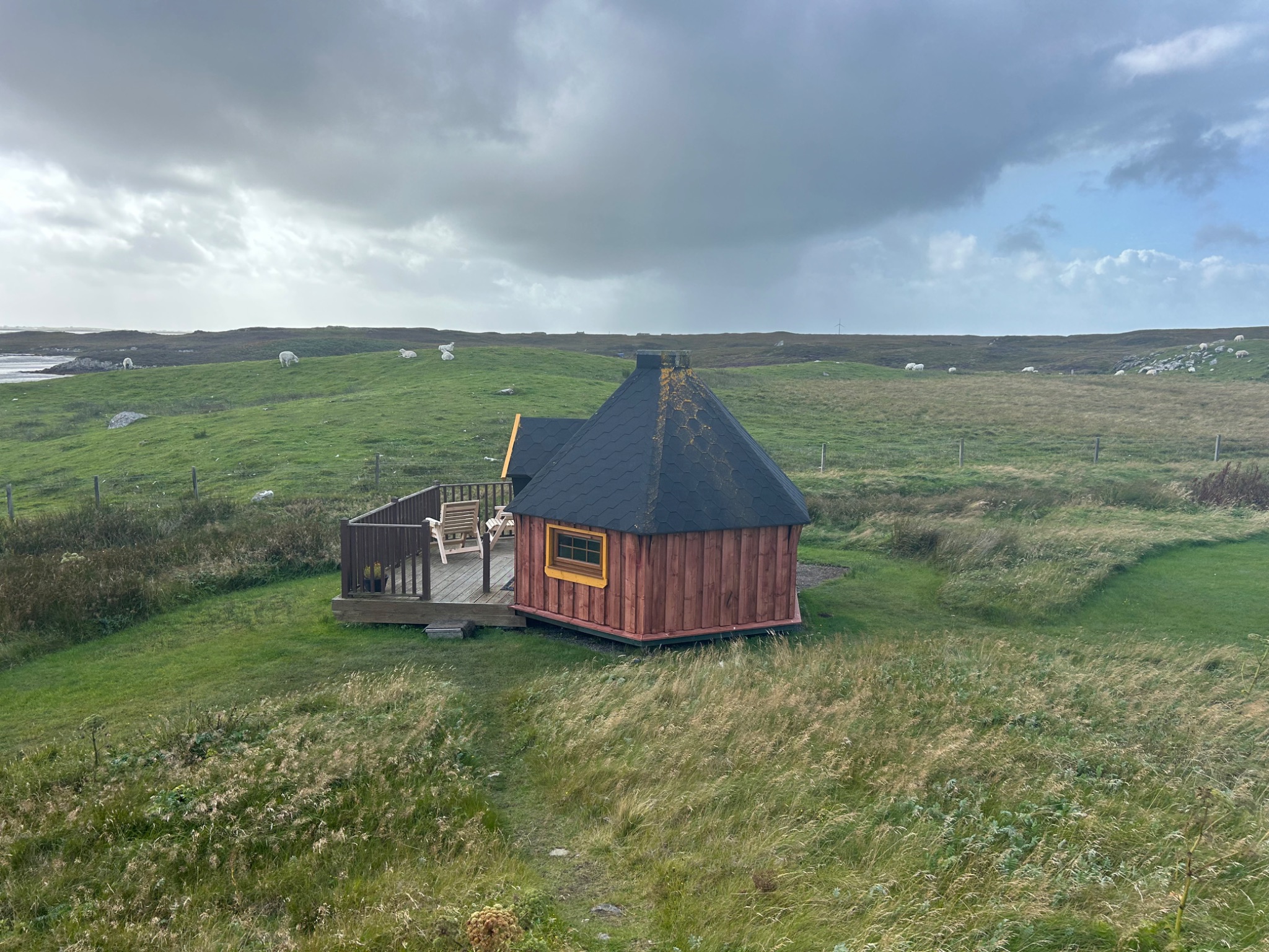 A small house in a grassy fieldDescription automatically generated