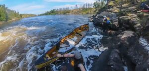 A group of people in a canoe in a river Description automatically generated