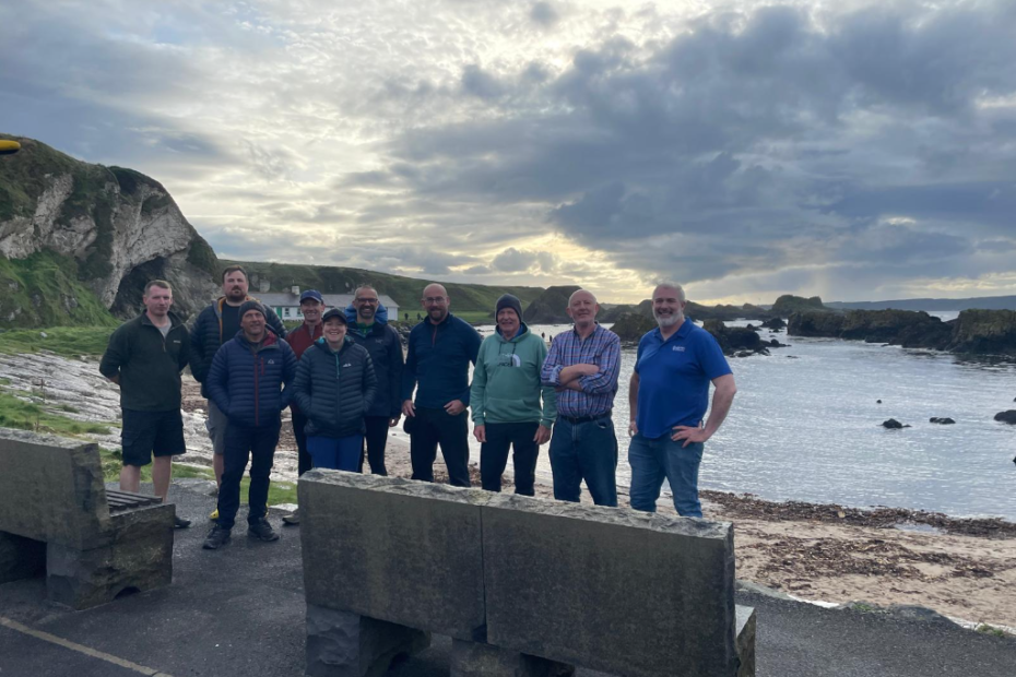 A group of people standing in front of a body of water Description automatically generated