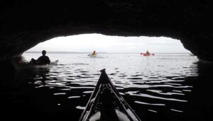 People kayaking in a cave Description automatically generated
