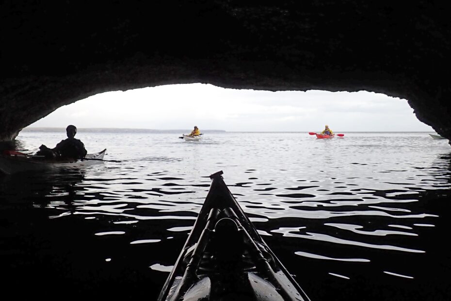 People kayaking in a cave Description automatically generated