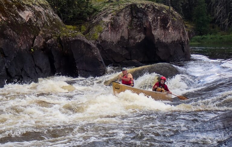 People kayaking in a river Description automatically generated