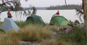 Two tents next to a lake Description automatically generated