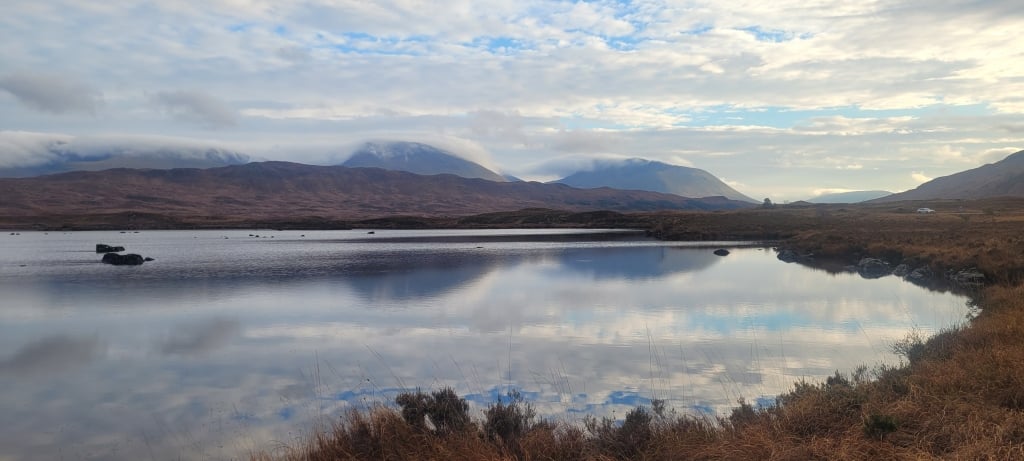 A body of water with mountains in the backgroundDescription automatically generated