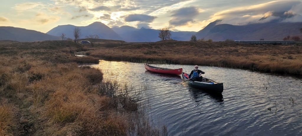 A person in a canoe on a riverDescription automatically generated