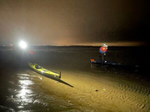 A person on a boat on the beach Description automatically generated