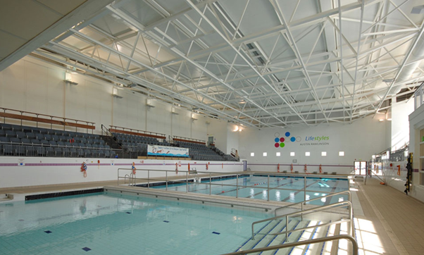 A swimming pool in a large indoor pool Description automatically generated