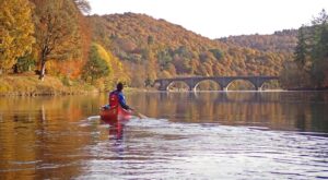 A person in a canoe on a river Description automatically generated