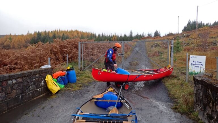 A person in a red canoe Description automatically generated